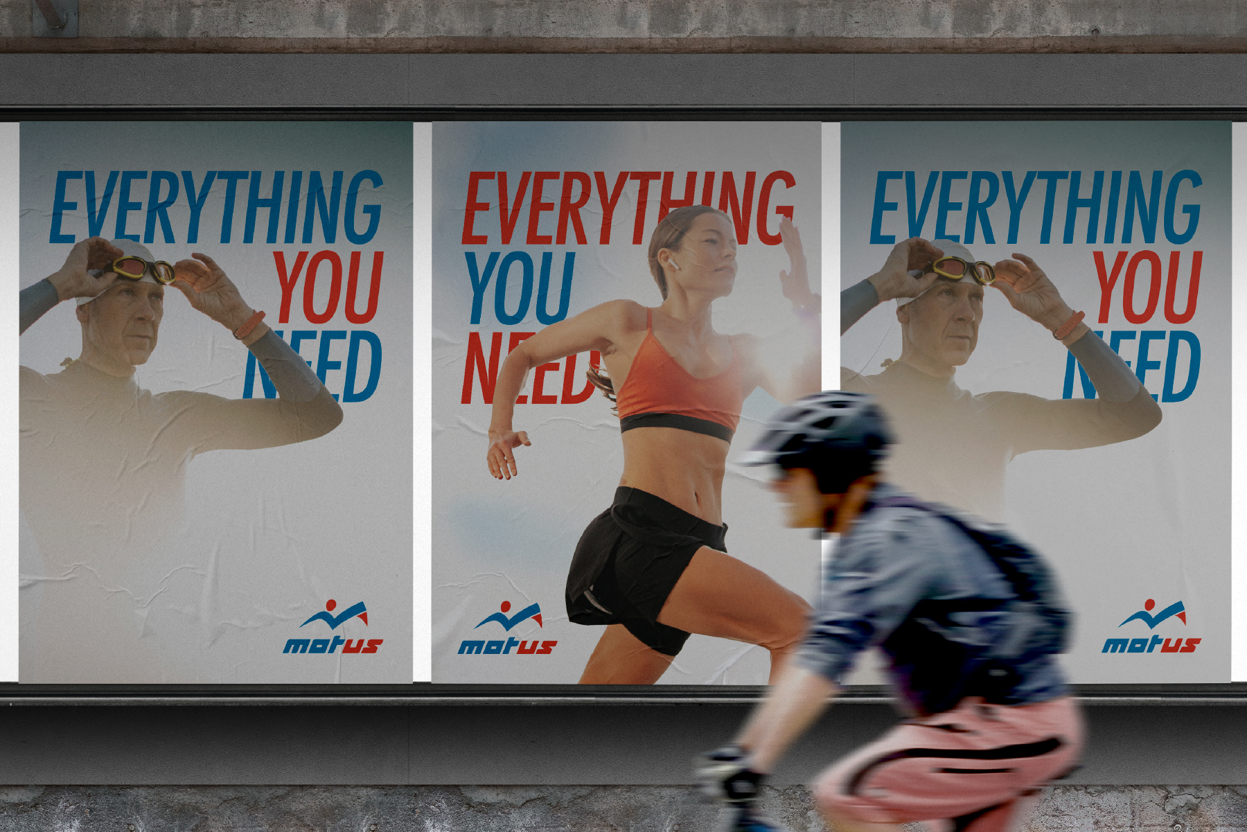 Manifesti della campagna Motus "Everything you need" mentre passa un ciclista